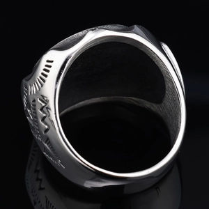 Macro shot of silver punk ring showing brushed metal texture and engraved skull pattern