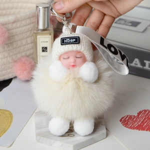 Close-up of fluffy fox fur sleeping doll keychain with knitted hat and metal clasp