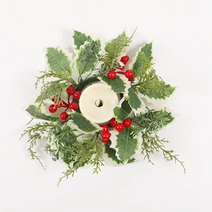 Christmas candle ring with artificial green holly leaves and red berries for table decor