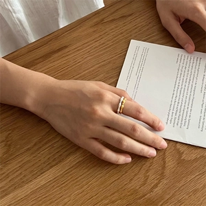 Minimalist S925 sterling silver olive bead ring worn on hand over a wooden table