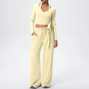 Détail d'un ensemble de yoga jaune pâle avec haut croisé à manches longues et pantalon