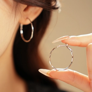 Macro shot of S925 sterling silver hoop earrings with irregular hammered texture detail