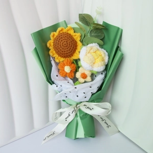 Detail of crochet sunflower and rose bouquet with green paper and white tulle wrapping