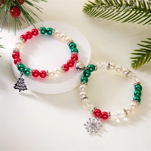 Christmas magnetic couple bracelets with festive tree and snowflake charms on white stand