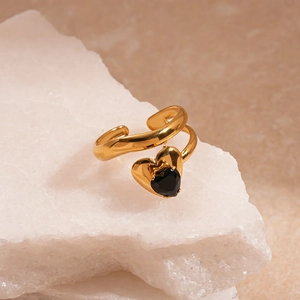 Vue détaillée d'une bague double couche dorée ornée d'un zircon noir en forme de cœur