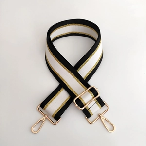Close-up of adjustable striped handbag strap with gold metal buckles and woven texture
