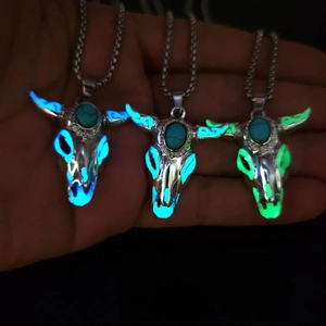 Luminous bull skull pendant necklace showing blue and green glow effects in the dark