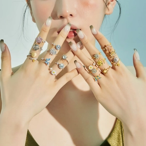 Close-up of S925 silver spinning rings with flower and bee motifs on a model's hand