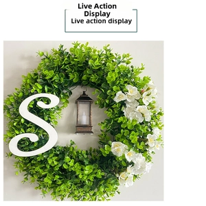 Detail of Christmas eucalyptus wreath with vintage lantern and decorative letter S