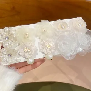 Elegant white floral earring set with pearls and rhinestones on a display card