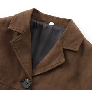 Detail of dark brown faux suede jacket collar with sharp lapels and visible texture