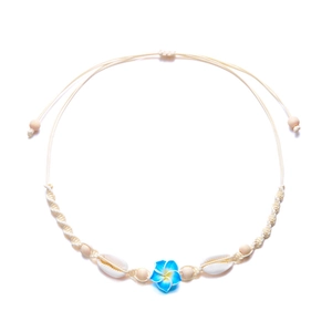 Detail der gewebten Strandhalskette mit blauer Blume, natürlichen Muscheln und Holzperlen