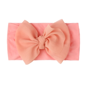Close-up of pink baby turban headband featuring a large layered chiffon bow decoration