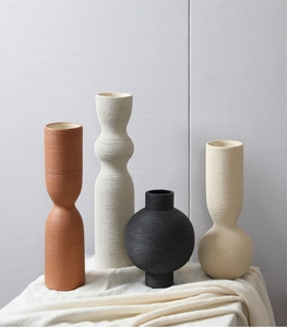 Macro view of textured Nordic ceramic vases with tactile brushed stripes and grainy surface