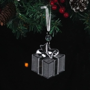Transparent Christmas gift box ornament with silver ribbon hanging on pine branch