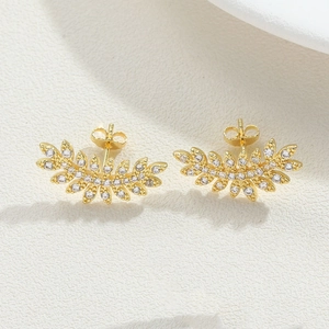 Detailed view of leaf-shaped gold stud earrings with shimmering micro-set zircons
