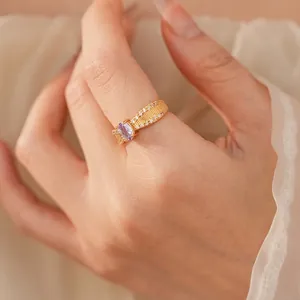 Goldring mit ovalem lila Zirkon, vertikaler Bürstentextur und seitlichen Mikrodiamanten