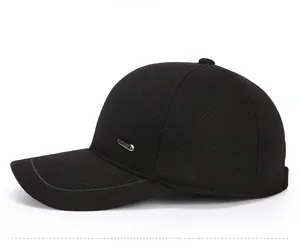 Detail shot of a black wool baseball cap featuring a decorative side metal plaque logo