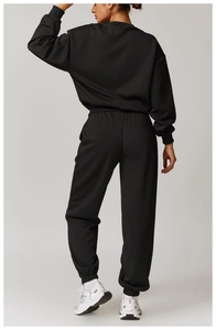 Vue arrière d'un ensemble de survêtement noir minimaliste avec sweat et jogging assorti