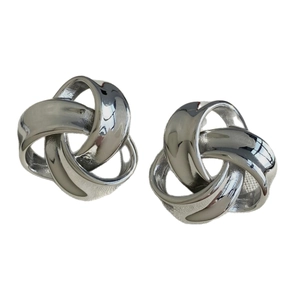 Polished silver stainless steel earrings with geometric twisted knot design on white background