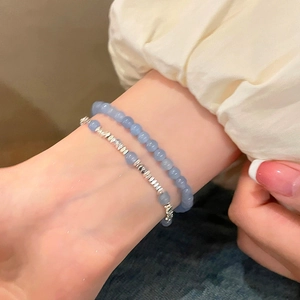 Gros plan d'un bracelet double couche en perles bleu clair avec espaceurs argentés