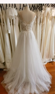 Exquisite close-up of beaded lace flowers and deep V-back detail on white wedding dress