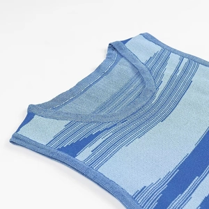 Gros plan sur l'encolure ronde et la texture tricotée de cette robe bleue à rayures