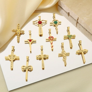Vue détaillée de 10 pendentifs croix dorés avec perles et pierres sur fond de soie