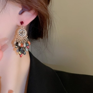 Gros plan détaillé de boucles d'oreilles vintage avec pompons en cristal sur un mannequin