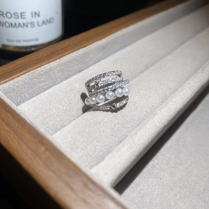 Vue macro d'une bague multicouche argentée avec perles blanches, étoiles et zircons brillants