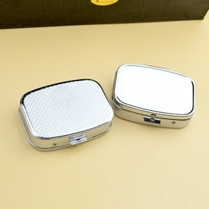 Close-up of portable silver metal pill boxes with brushed and mirrored finish surfaces