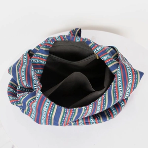 Macro detail of ethnic woven tote interior showing black lining and zip pocket