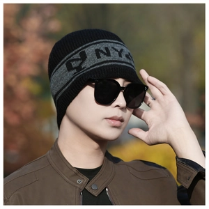 Détail du bonnet en tricot noir et gris avec motif NY et protection des oreilles