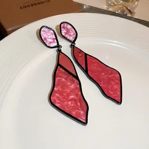 Modern geometric acrylic drop earrings with red marble pattern and black frames