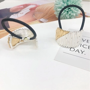 Macro detail of alloy arched hair tie with vertical texture and bicolor metal finish