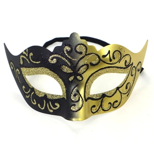 Macro detail of black and gold masquerade mask with glitter scroll patterns
