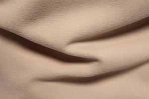 Macro shot of khaki cotton fabric texture showing fine knit details and soft folds