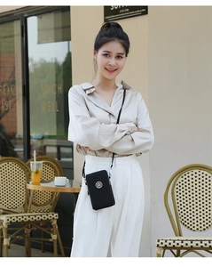 Gros plan sur le mini sac bandoulière noir pour téléphone avec double fermeture éclair et logo