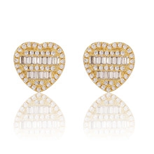 Gros plan de boucles d'oreilles cœur dorées avec pavé de zircons blancs étincelants
