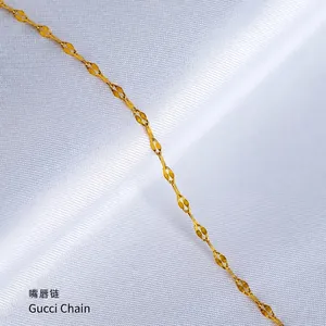 Detailed view of polished gold lip chain necklace laid on white textured fabric background