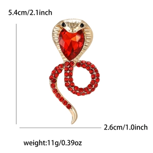 Golden cobra brooch with red heart stone and crystal inlay, measuring 5.4cm by 2.6cm