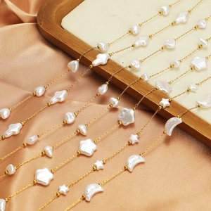 Gold stainless steel necklace with star, moon, and heart pearl pendants on satin background