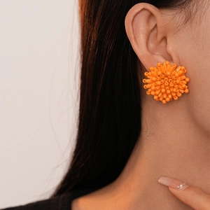 Detailed view of vibrant orange cluster beaded earrings handcrafted with glossy resin beads