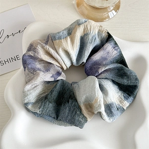 Vue détaillée du grand chouchou en tissu tie-dye aux motifs abstraits bleus et beige