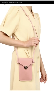 Detailed close-up of pink leather crossbody phone bag with round metal buckle and fine stitching