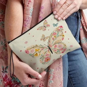 Floral butterfly makeup bag with black zipper and wrist strap held by a model