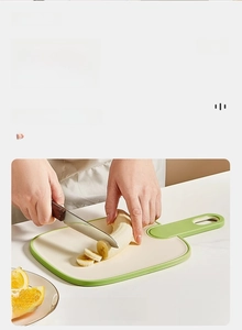 Close-up of a food-grade small plastic cutting board slicing a banana for baby food
