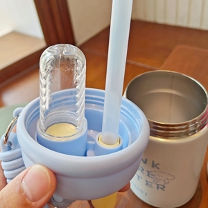 Detail of blue lid with straw and food-grade silicone seal on stainless steel cup