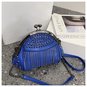 Detail of electric blue leather bag featuring black rivets and metallic fringe chains