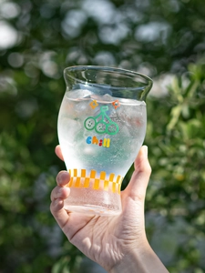 Close-up of a high borosilicate glass featuring cherry patterns and chill text with ice
